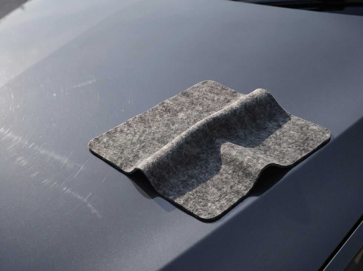 Light swirl marks on a dark grey panel